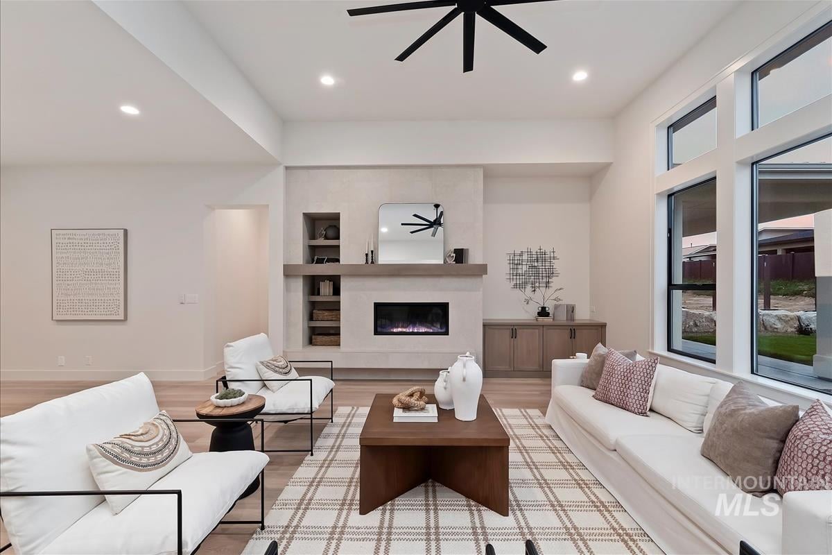Living room with a gas fireplace in a smooth stucco wall, oak mantle and oak built-in cabinets