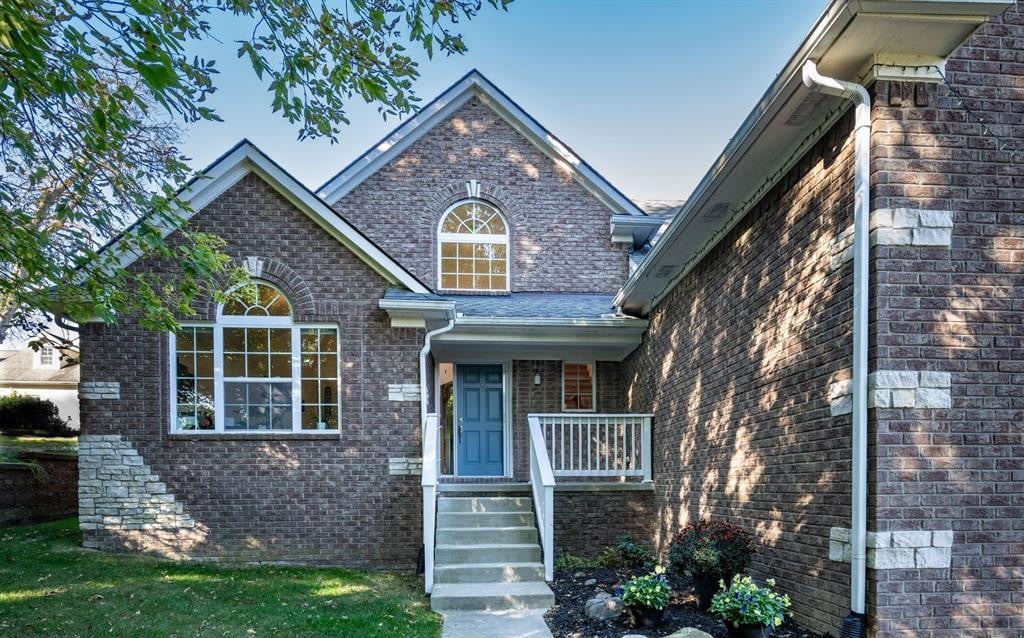 Brick home with a blue front door, arched windows, and a small covered porch.