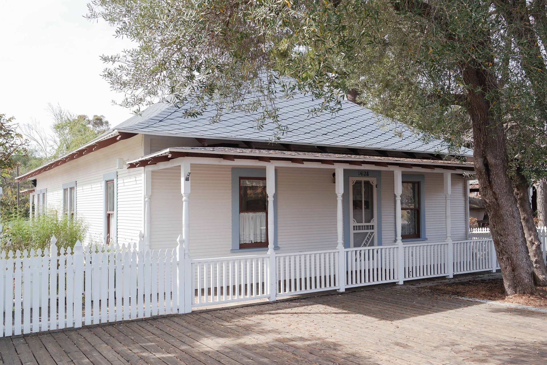 The white wood-frame Nelson House with its front porch and picket fence at Old Poway Park in Poway, February 2014