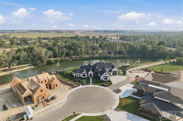 Aerial homes along a river, with one under construction beside a cul-de-sac.