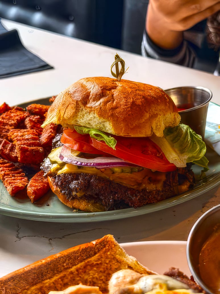 Loaded burger with lettuce, tomato, onion and cheese, served with seasoned potato wedges.