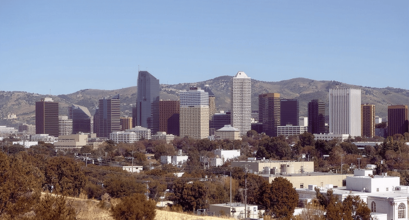 City skyline of high-rise buildings backed by dry hills.