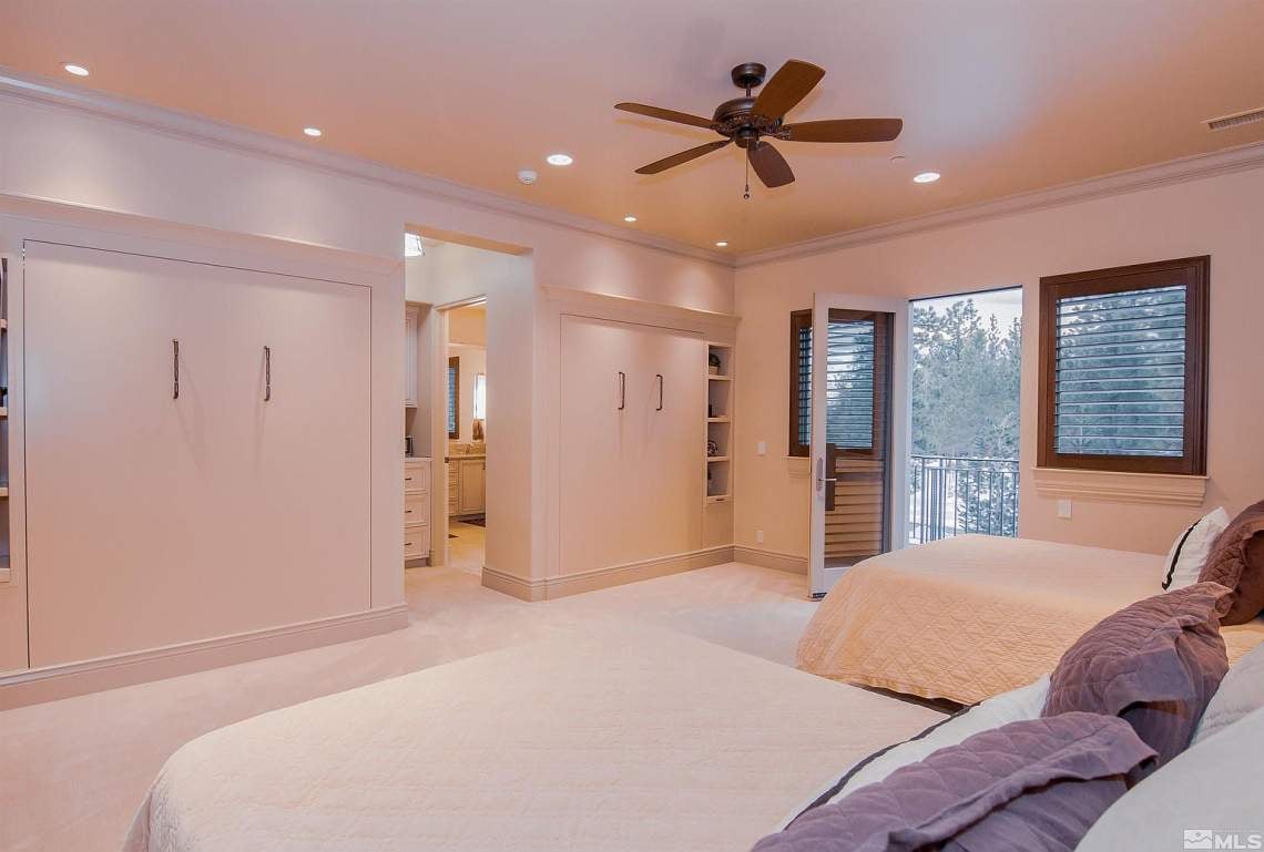 Furnished bedroom with built-in closets, two beds, and a balcony door.