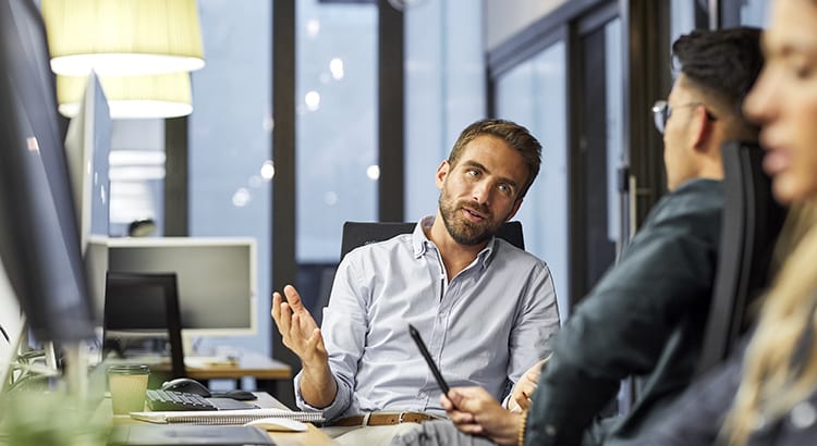 office people having a conversation at their desk