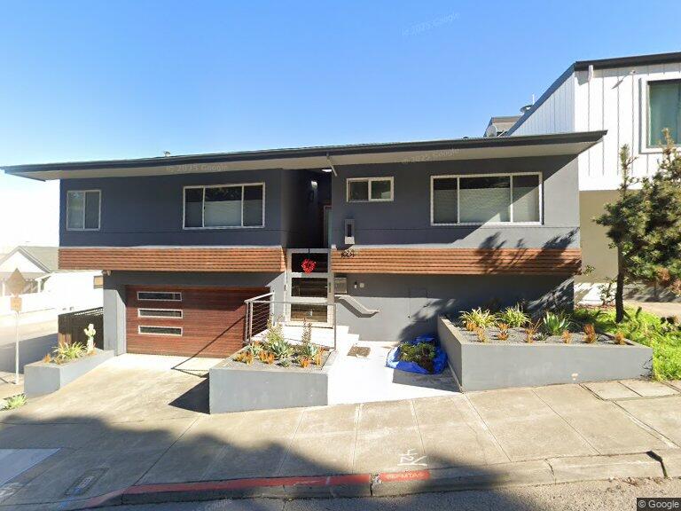 Modern gray home with horizontal wood siding, a garage, and raised front garden beds.