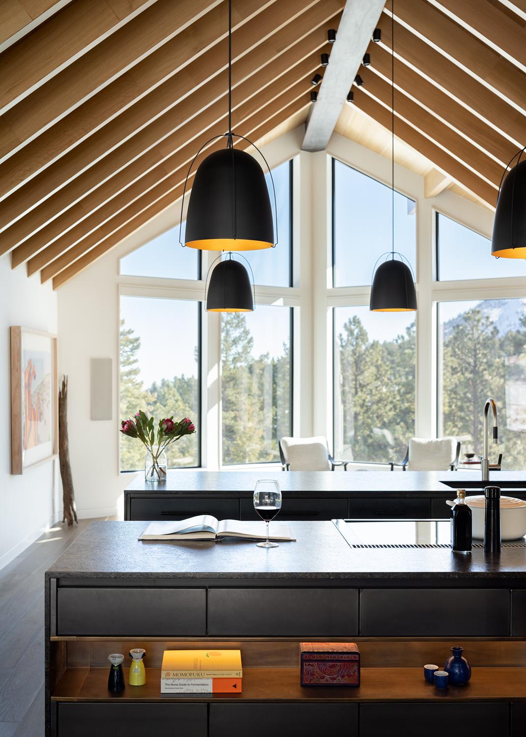 Modern Boulder kitchen with vaulted ceiling, black pendant lights, and floor-to-ceiling windows overlooking mountain landscape