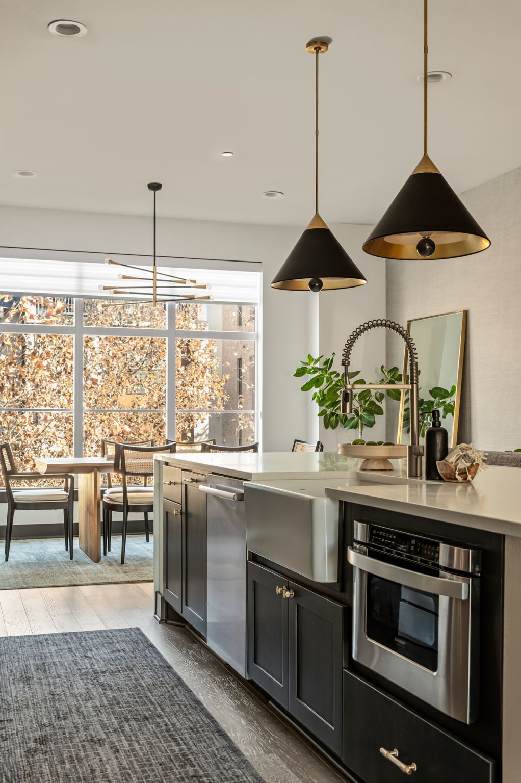 Kitchen detail at 4507 Unity Circle in The Grove, Austin, with stainless appliances and a dining nook beyond, upgrades by Ashley Walker Designs.