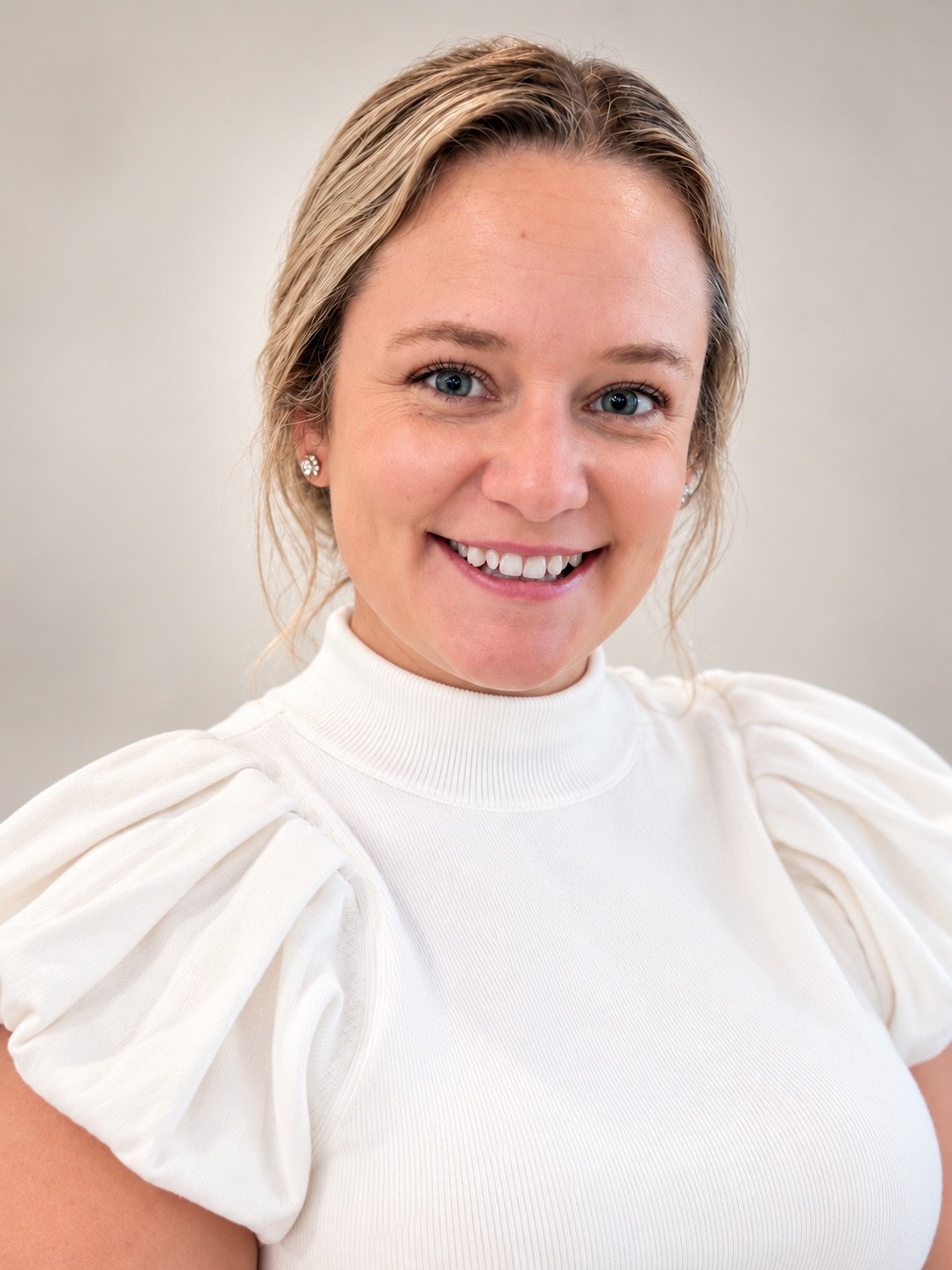 Brittany Streets smiling in a white high-neck blouse.
