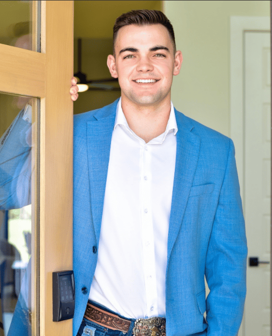 Keaton Vaughn smiling in a blue suit jacket while standing in a doorway.