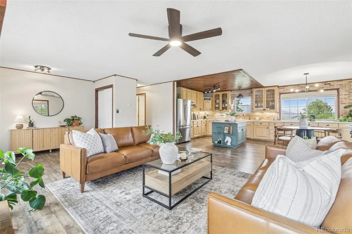 Open-concept living room with leather sofas transitioning into the kitchen and dining area at 278 Overlook Drive.