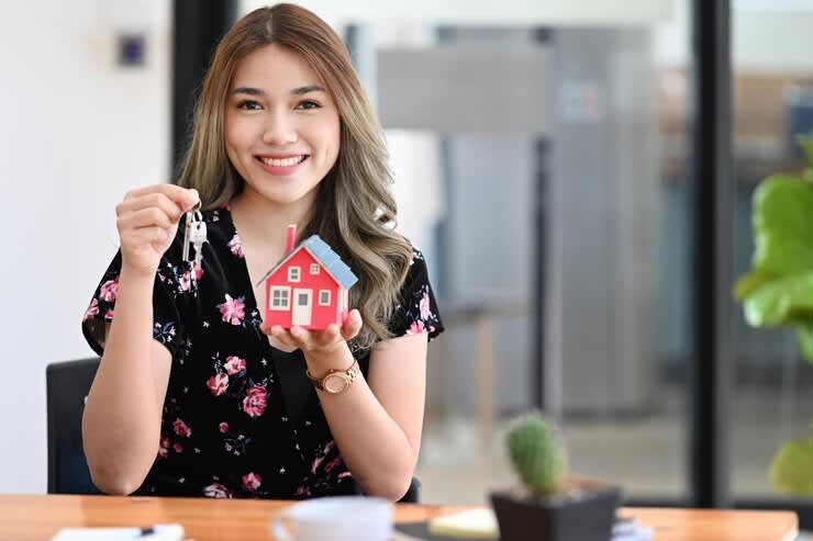 beautiful asian woman holding house model and key