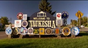 Welcome to Waukesha sign surrounded by local service club emblems at a roadside entrance