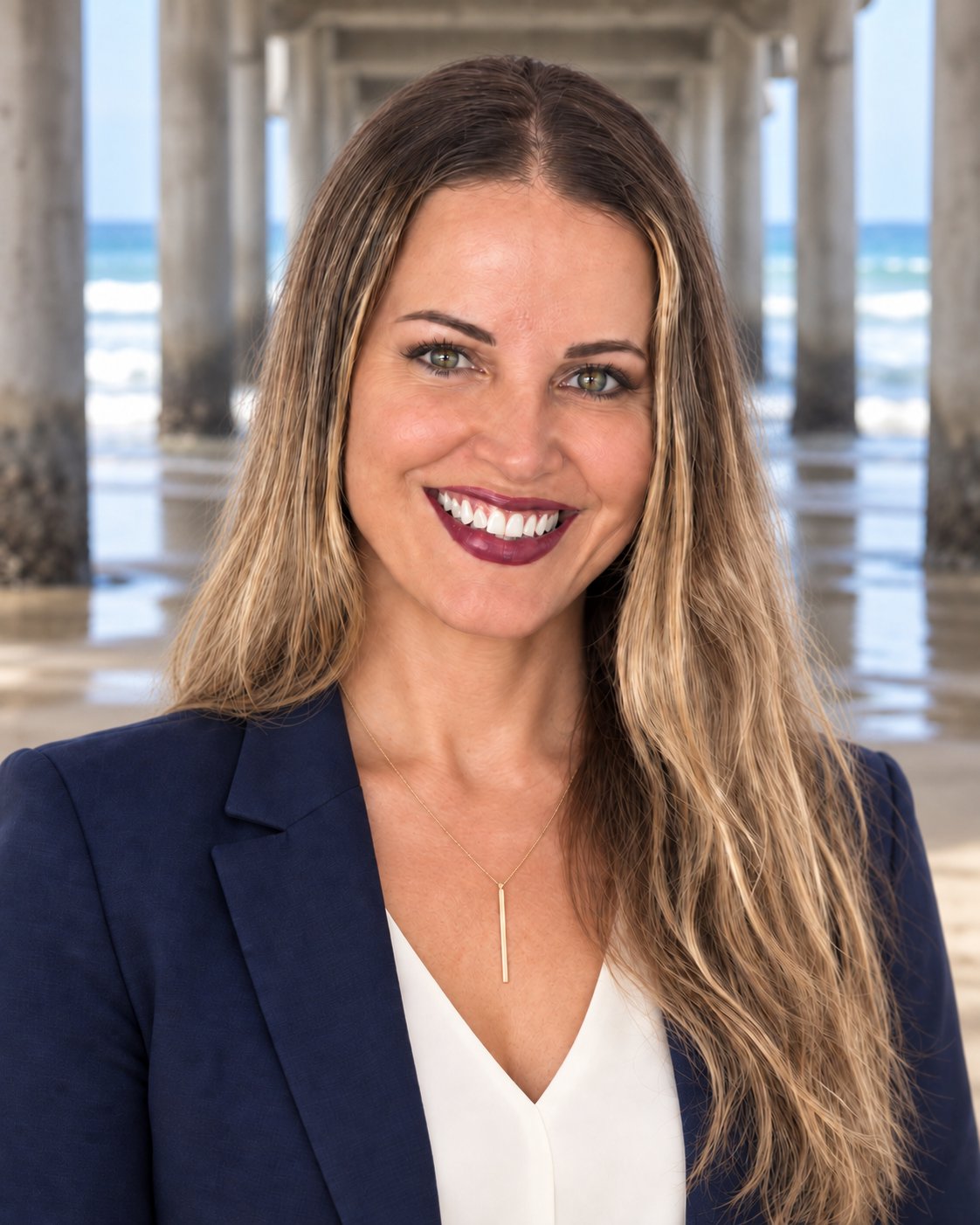Melissa Hill smiling in a navy blazer, with the beach and pier behind her.