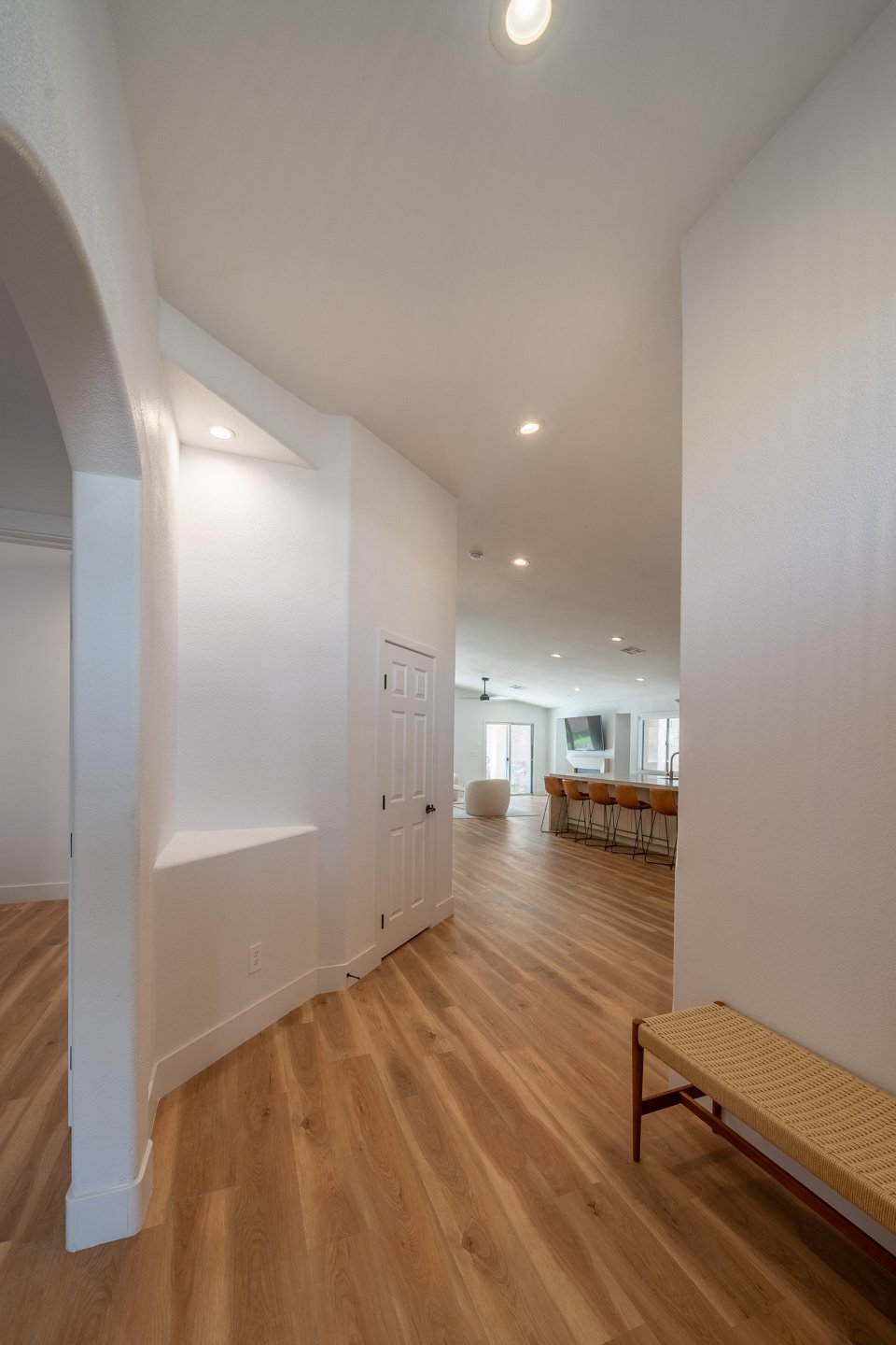 Bright hallway with wood flooring and a view toward the kitchen island.