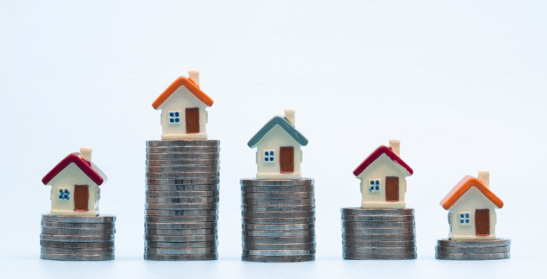 Model houses sit atop coin stacks of varying heights.