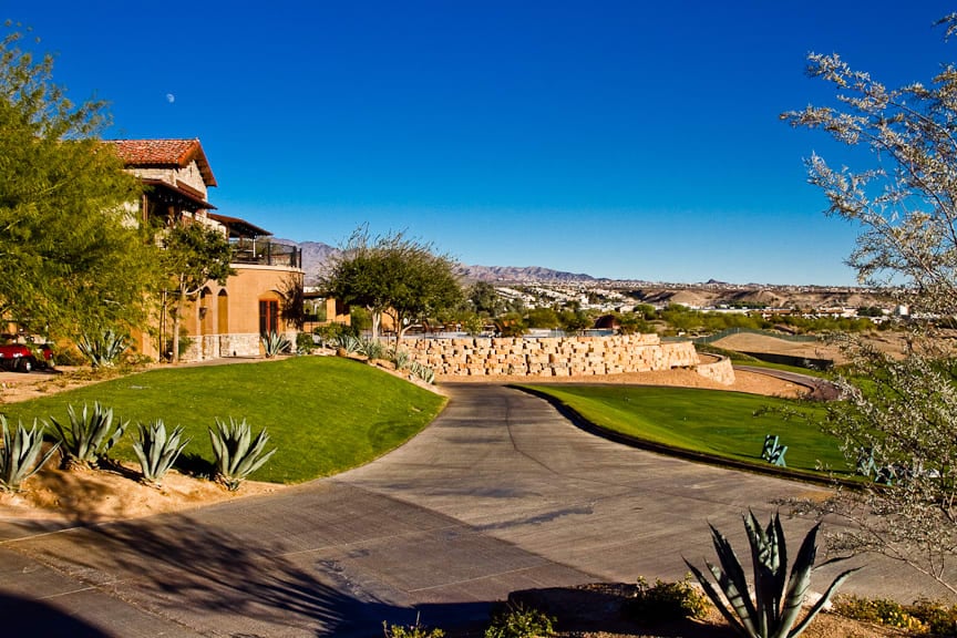 Lush golf course, mountain views, modern luxury home with patio - perfect for upscale community living.