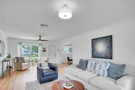 Living room with a pale sectional, blue armchair, and sliding doors to a garden patio.