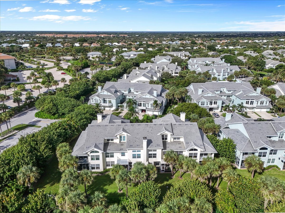 Aerial view of Sea Colony’s light-colored condominium buildings, palm trees, and landscaped grounds.