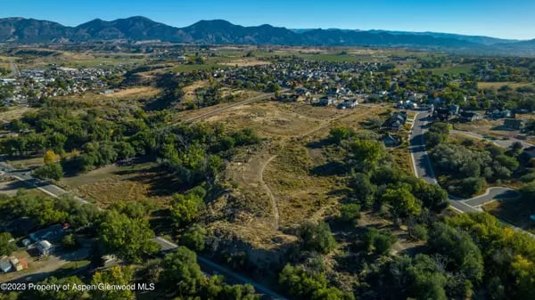 Aerial view of Rifle, Colorado, with neighborhoods, open land, and mountains.