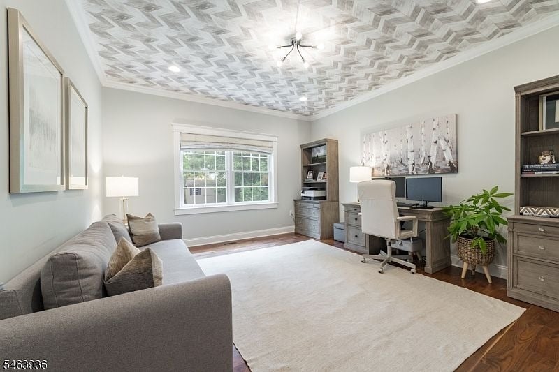 Home office with a gray sectional, desk, computer, and distinctive patterned ceiling.