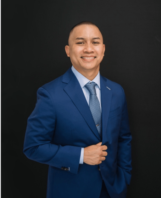 Vanny O in a blue suit and patterned tie.