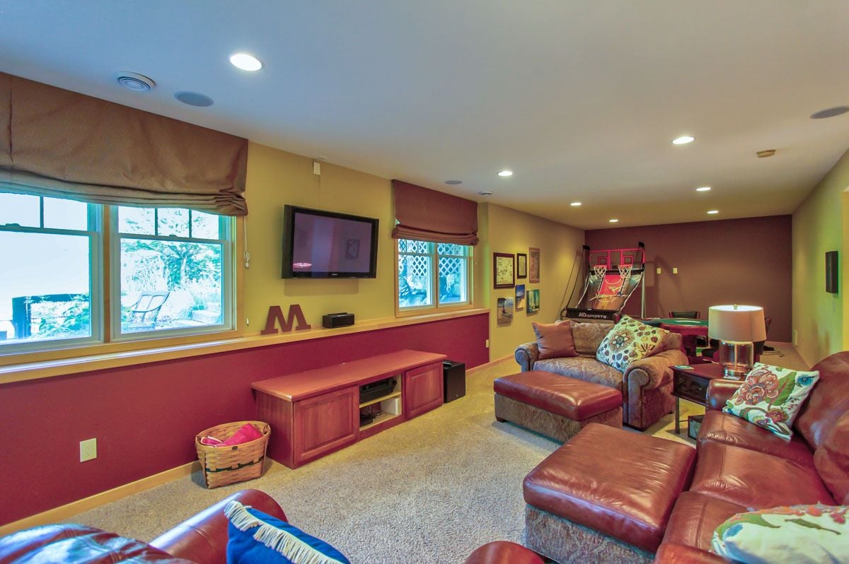 Recreation room with leather seating, a television, and a tabletop basketball game.