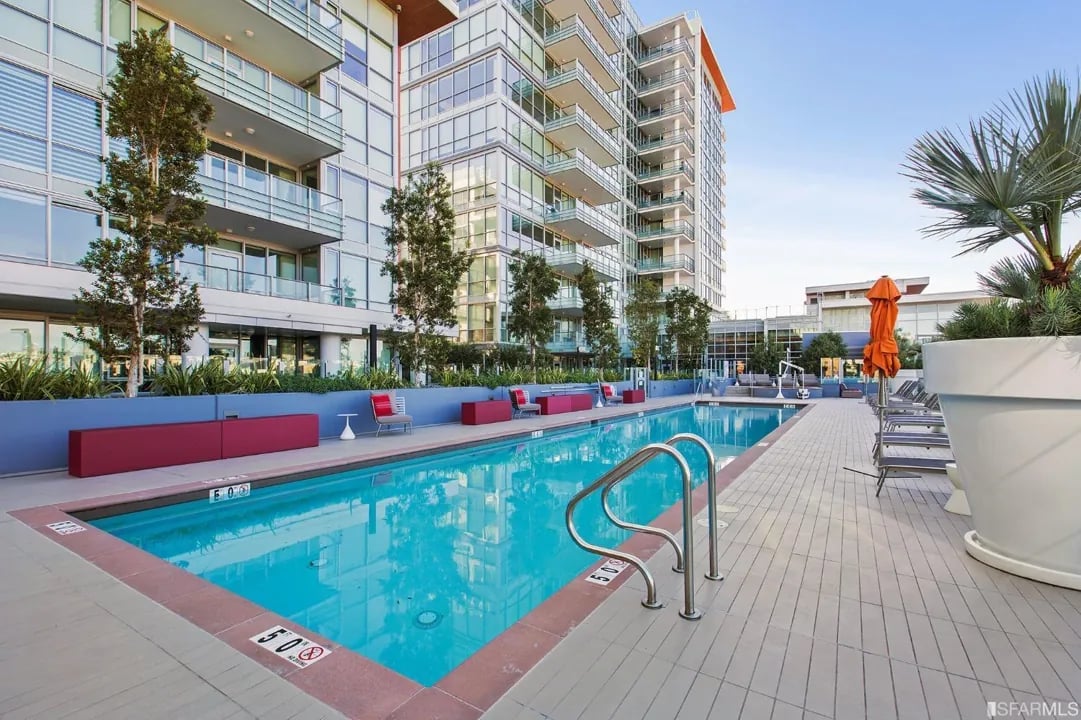 Arden Residences rooftop pool with lounge chairs and the building's facade. The pool is 5'0" deep.
