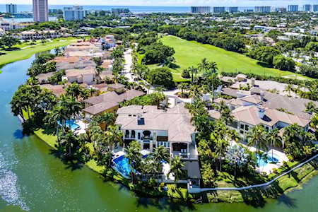 Aerial view of East Boca homes beside waterways, with swimming pools and a broad green open space.