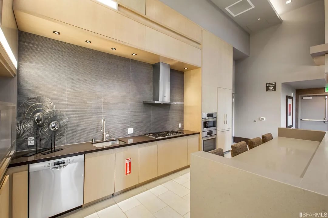 Arden Residences communal kitchen with an island, bar seating, and stainless steel appliances.