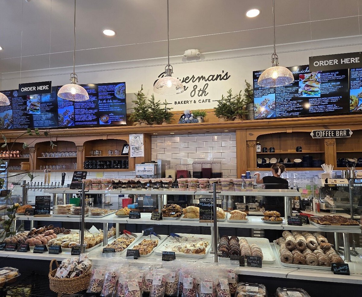 Interior counter at Bowerman’s on 8th with blueberry drinks, desserts, and café menu boards