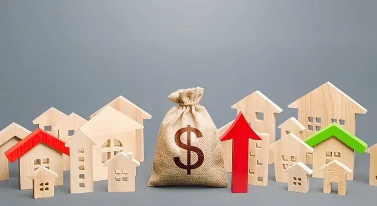 A burlap sack with a dollar sign and small house models around it, along with an upward-pointing red arrow. This image represents financial growth or real estate investment.