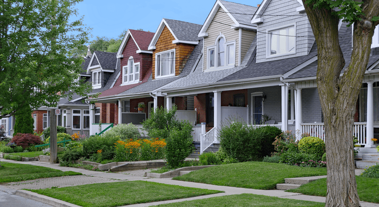 A photo of a row of houses with well-maintained lawns, indicating topics related to real estate, neighborhood, or housing market.