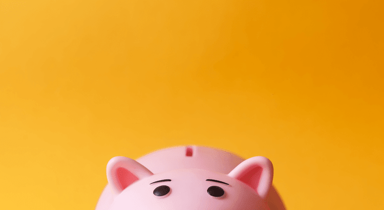 A pink piggy bank sits against a bright yellow background, symbolizing savings and financial planning.