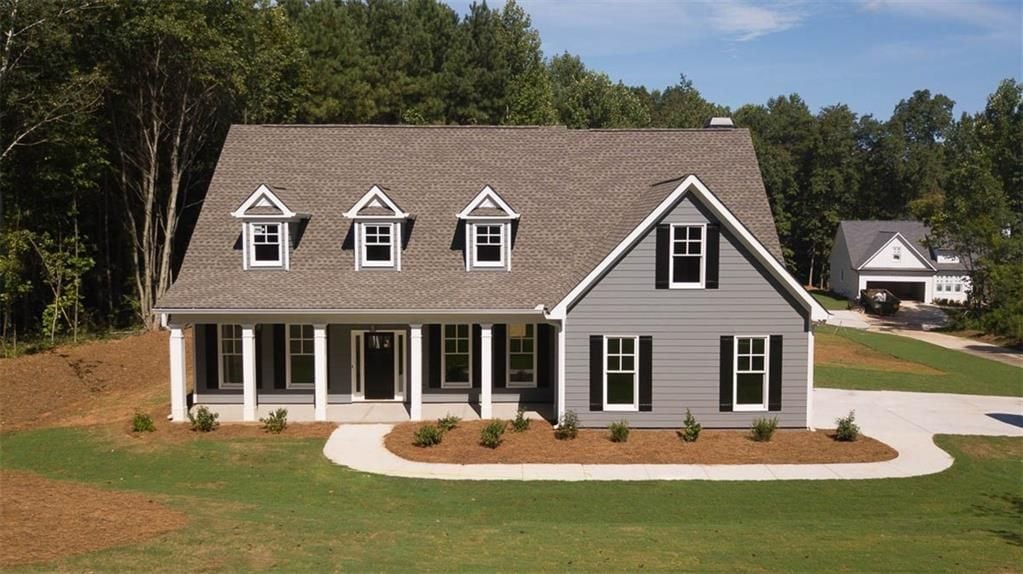 Gray two-story house with three dormers, a covered porch, and a curved walkway.