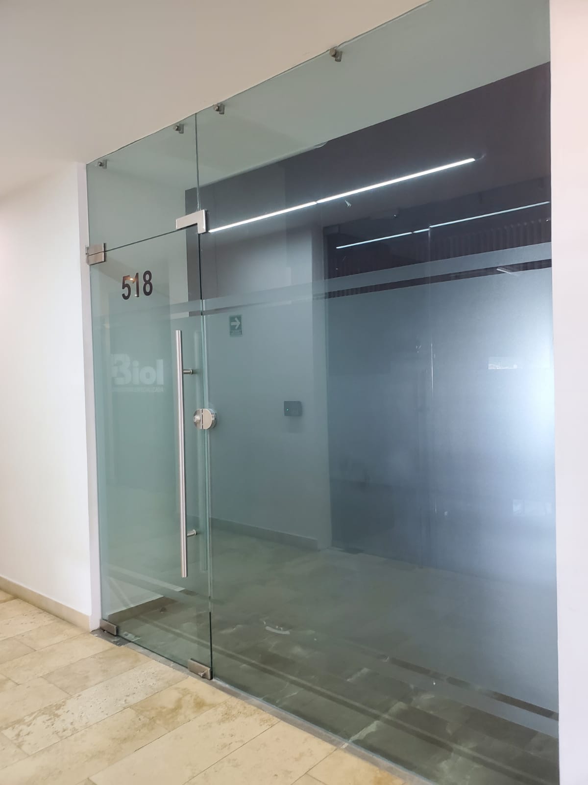 Vacant office 518 behind a full-height glass entrance with a metal handle.