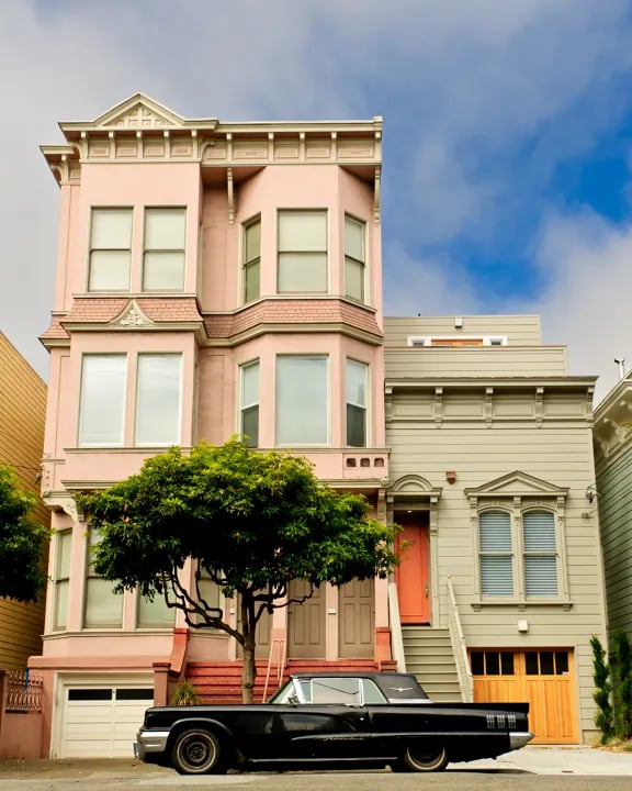 Colorful Victorian houses in Pacific Heights San Francisco with classic architecture and vintage car parked on street