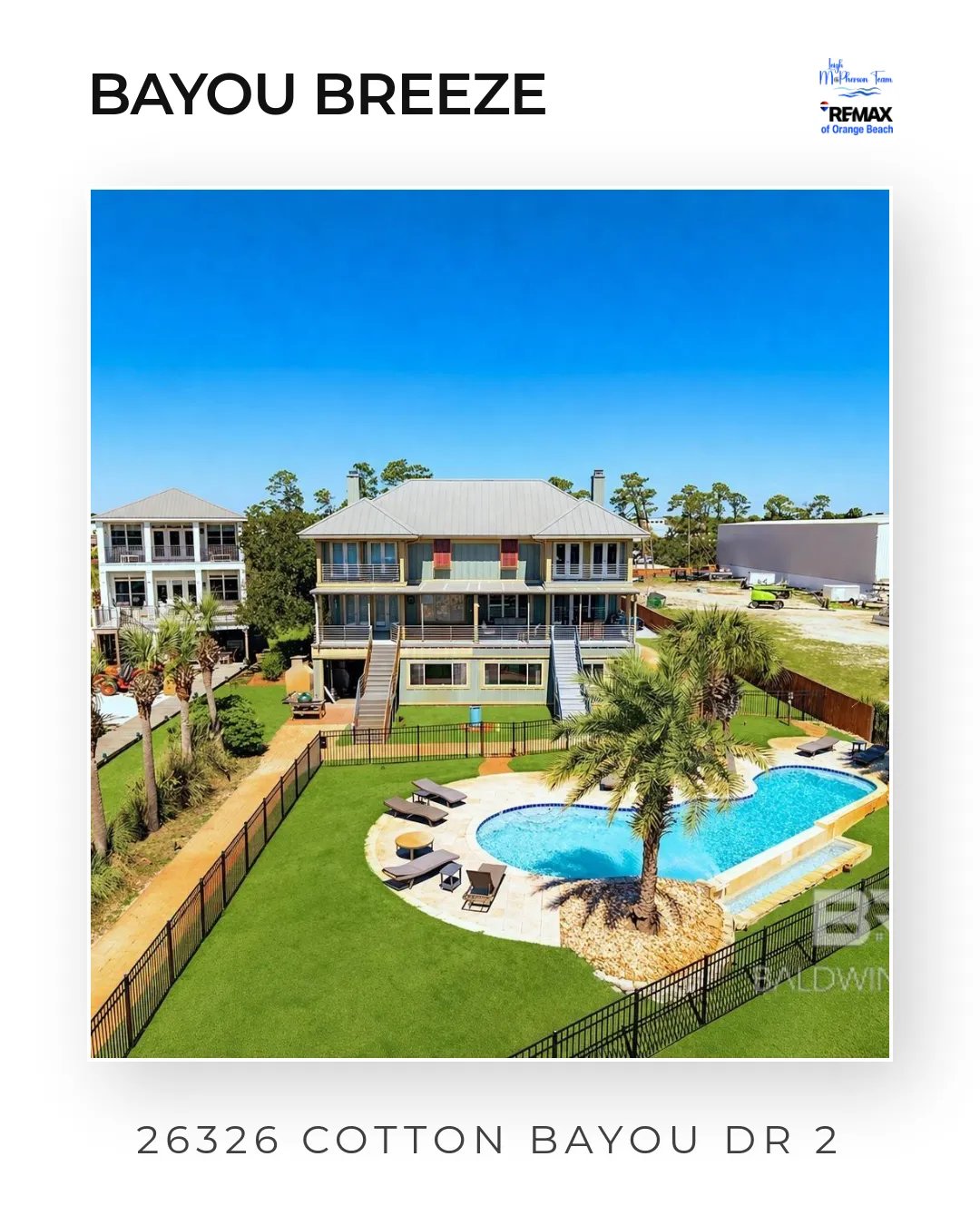 Luxury waterfront home with private pool and lush green lawn at 26326 Cotton Bayou Dr in Orange Beach, Alabama, featuring multi-level coastal architecture, spacious outdoor living, and direct bayou access for boating.