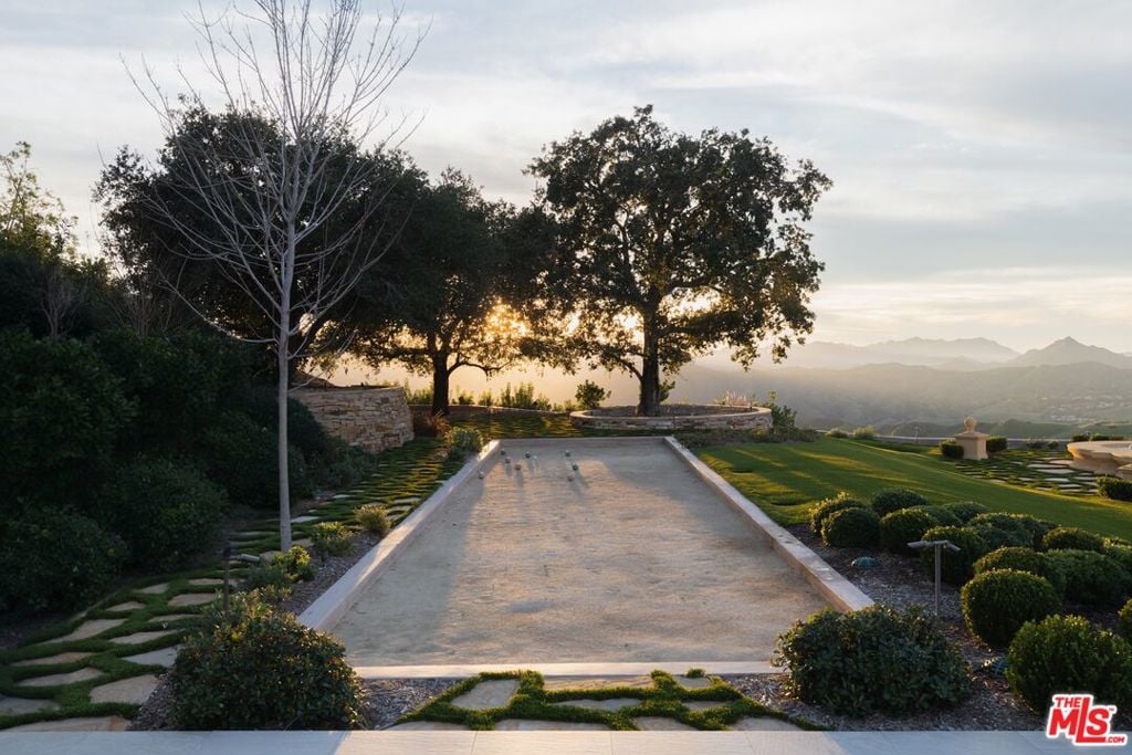 Landscaped bocce court with mountain views at sunset.