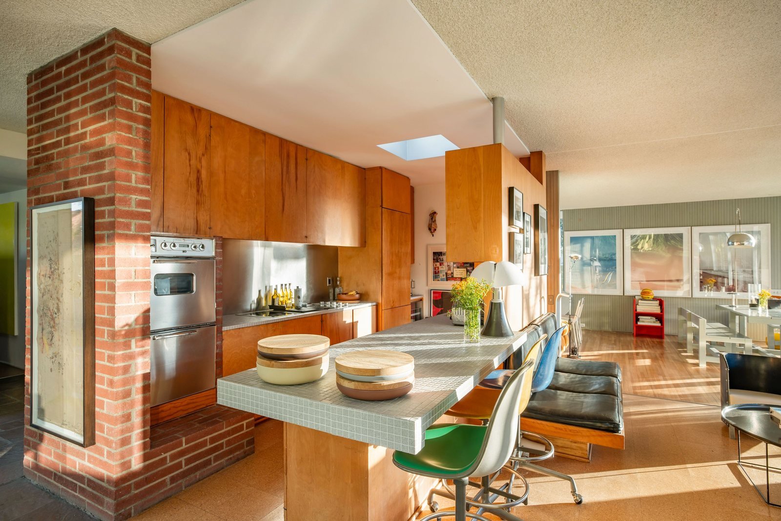 Kitchen of the Sale House with original wood cabinetry and a brick chimney mass at its centre.
