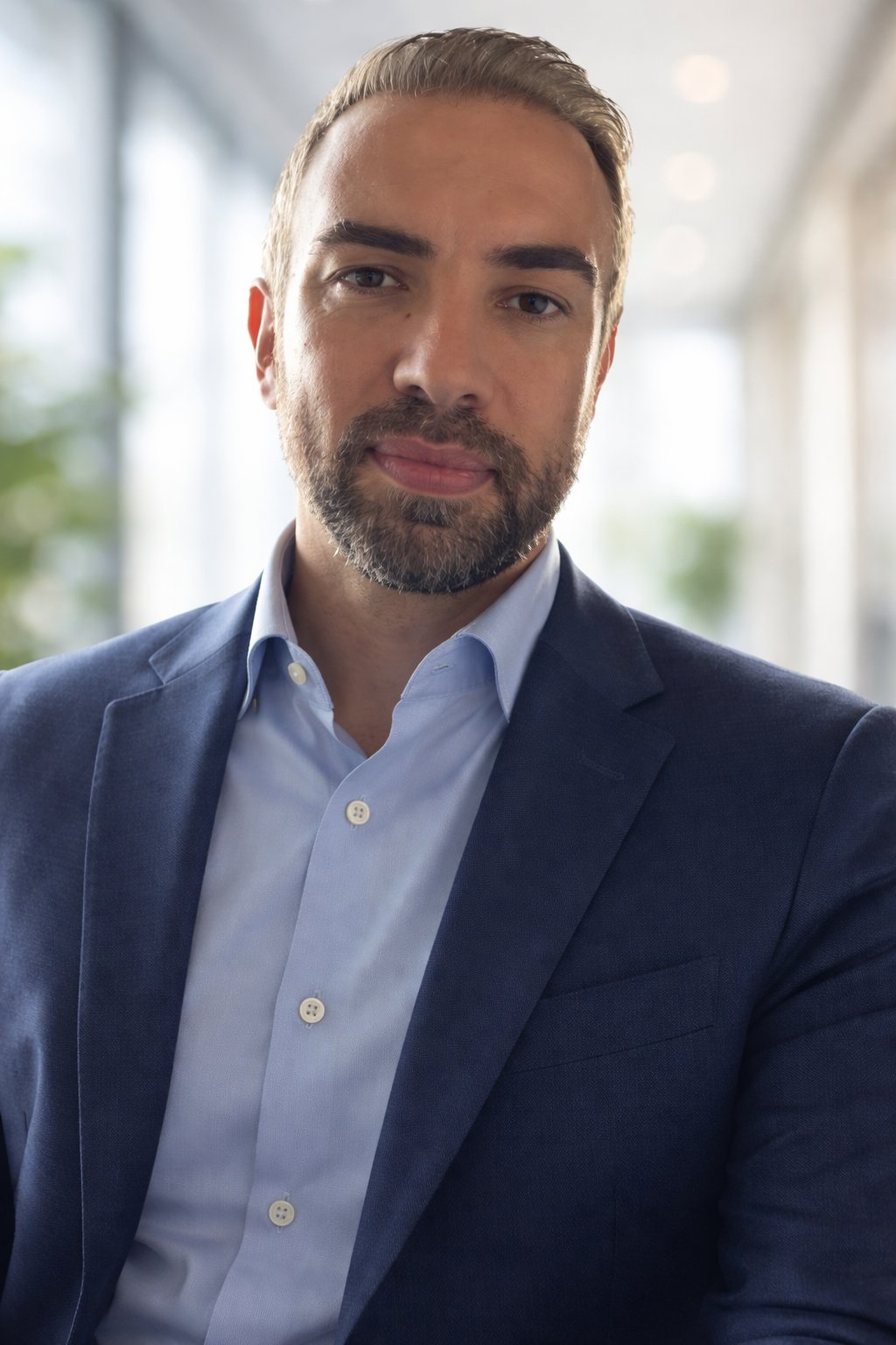 Ali Movaghar in a navy suit jacket and light blue shirt.