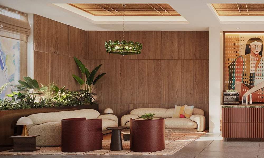 Residential lounge with curved cream sofas, burgundy tables, wood-paneled walls, and a colorful artwork.