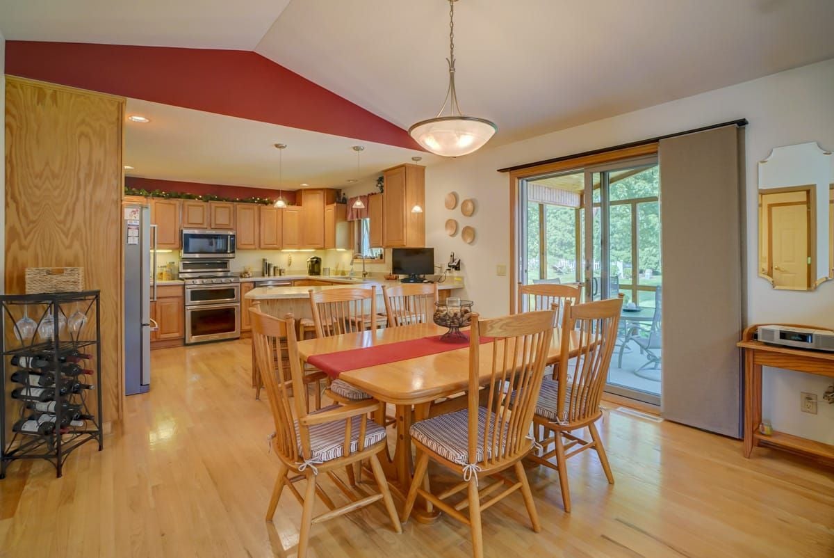 Open kitchen and dining area with a wooden table and sliding doors to a covered patio.