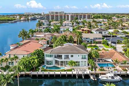 Aerial view of East Boca waterfront homes along palm-lined canals, with private docks and boats.