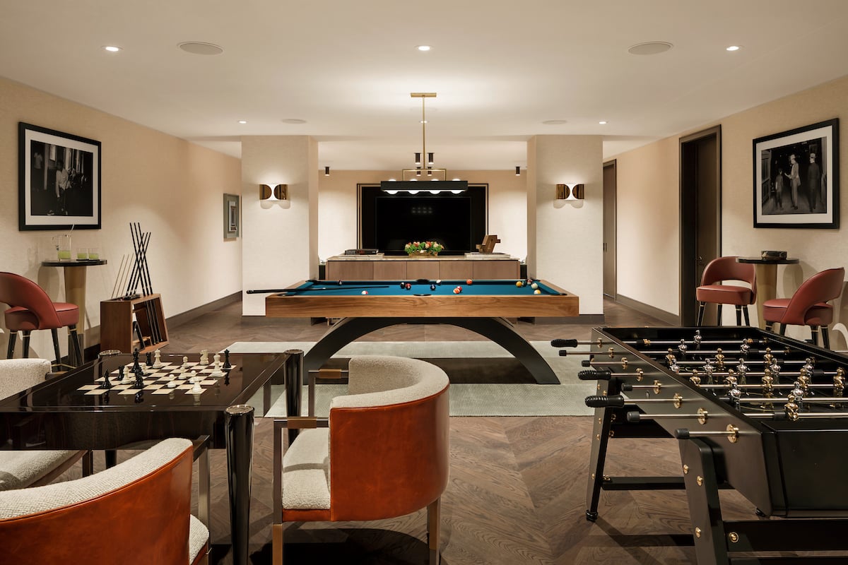 Furnished game room with pool and foosball tables, a chess set, and lounge seating.