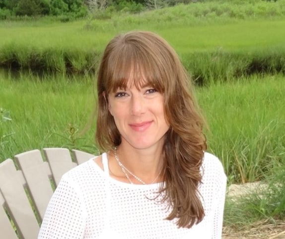 Sarah Finnell seated outdoors in a white top.