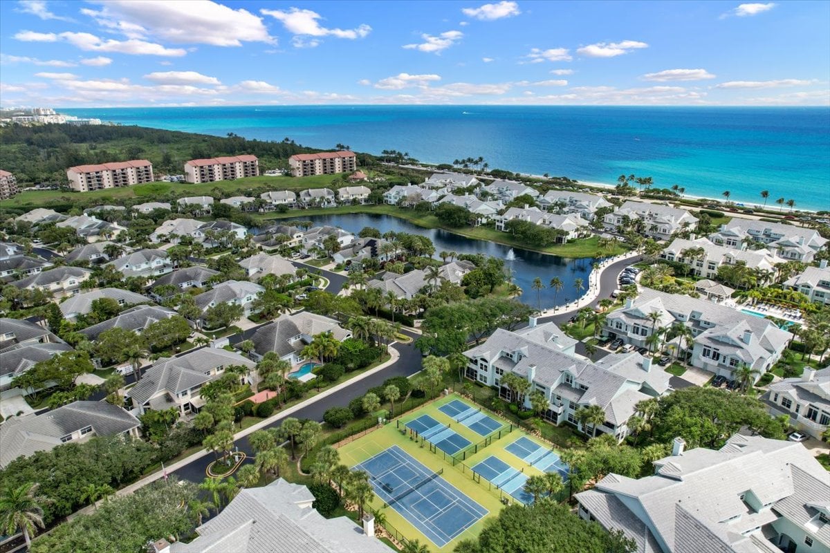 Aerial view of Sea Colony’s coastal community, with tennis courts, a lagoon, homes, and oceanfront condominiums.