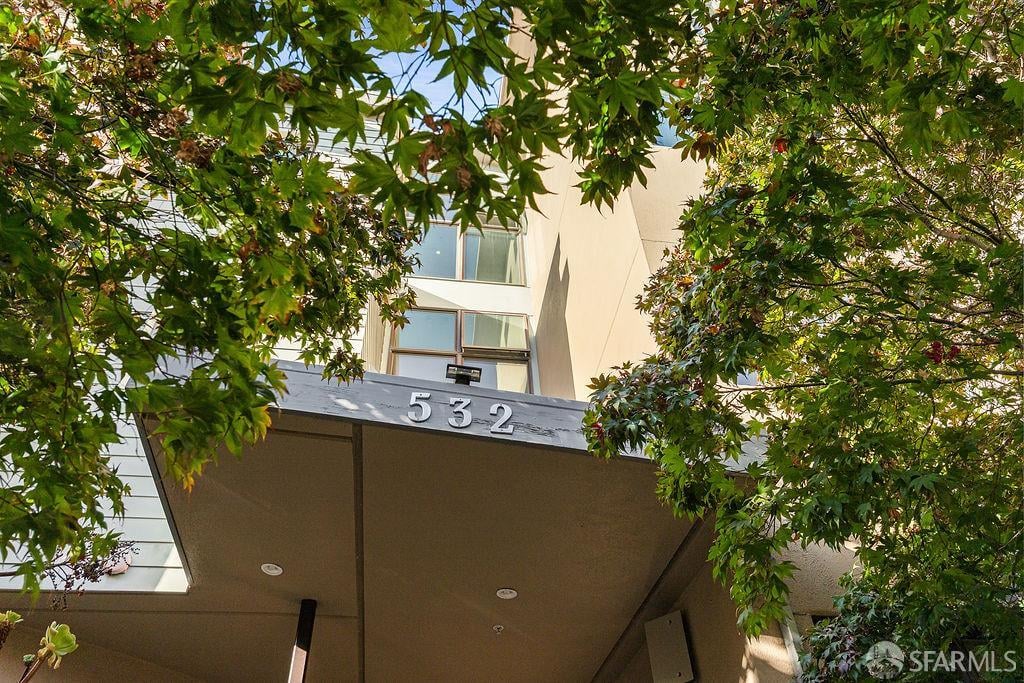 Modern building entrance marked 532, framed by leafy trees.