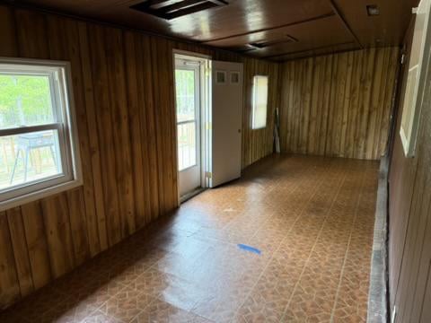Empty wood-paneled room with patterned flooring and a glass-panel door.