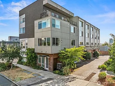 Modern multi-story Seattle residence with balconies, large windows, and landscaped walkways.