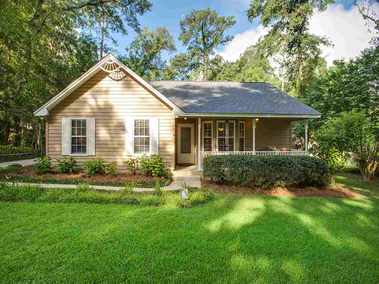 A cozy home nestled among trees in a serene wooded neighborhood setting.